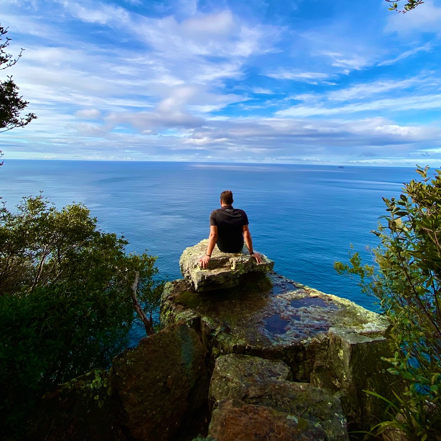 Matthew Fornaciari looking out from a cliff edge over the ocean